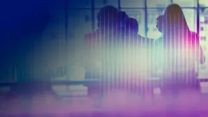 Work team in discussion during a meeting with soft colourful lighting.