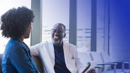 Male medical professional engaging in conversation with female patient.