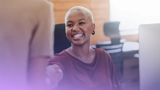 Professional female shaking hands and smiling.