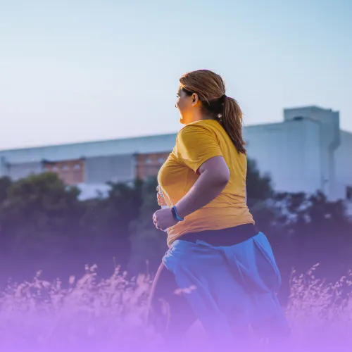 Smiling plus-size woman jogging outdoors.