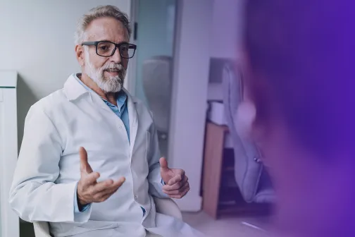 Male medical professional in consultation with a patient.