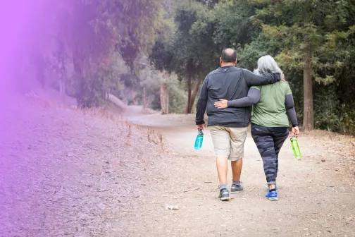 Middle-aged overweight couple walking together outdoors.