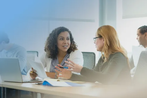 Two female employees collaborating in deep conversation.